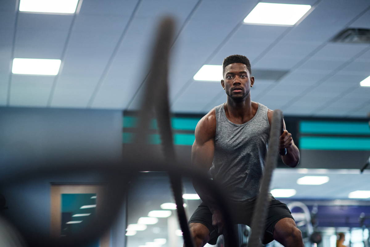 athlete and battle rope at gym
