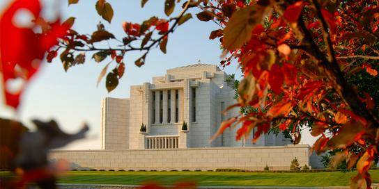 Cardston Temple framed by red leaves.