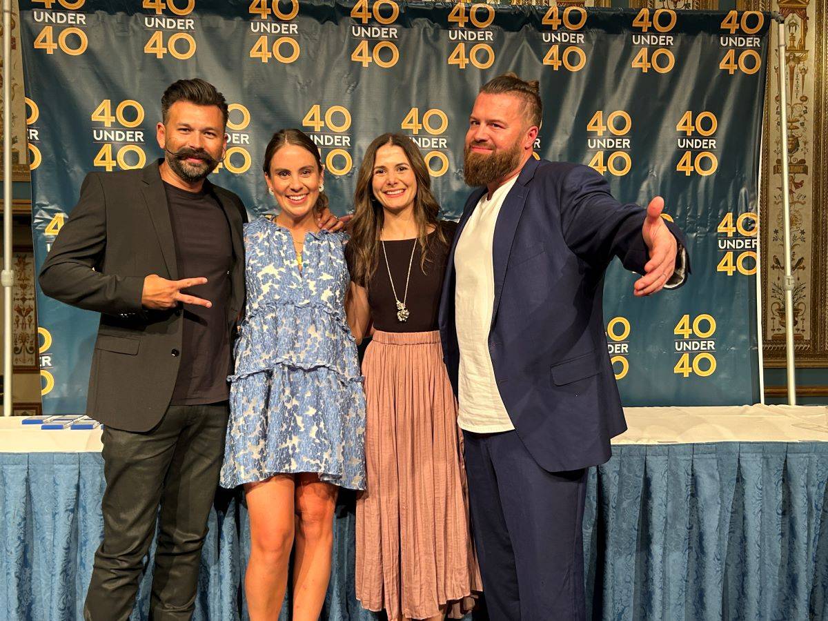 Previous award recipients Tim Morgan (left) and Andrew Cooley (right) join Summer Rogers and Camila Ramirez on stage at the 40 Under 40 ceremony.