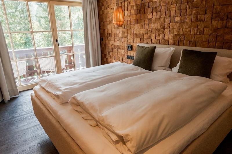 Gemütliches Schlafzimmer mit Doppelbett und Holzverkleidung im Apartment von Hugo & Pepi.