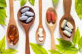 wooden spoons, each holding different vitamins that are found in wheat grass