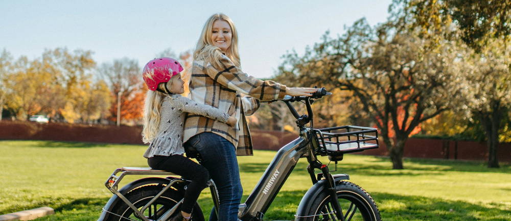 Mom on electric bike with daughter passenger