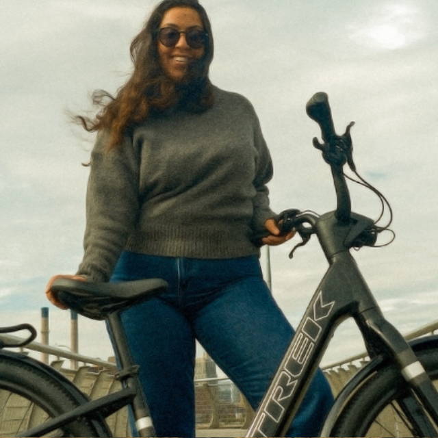 a woman standing next to a Trek electric city bike