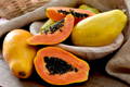 sliced papaya with their seeds piled into a basket