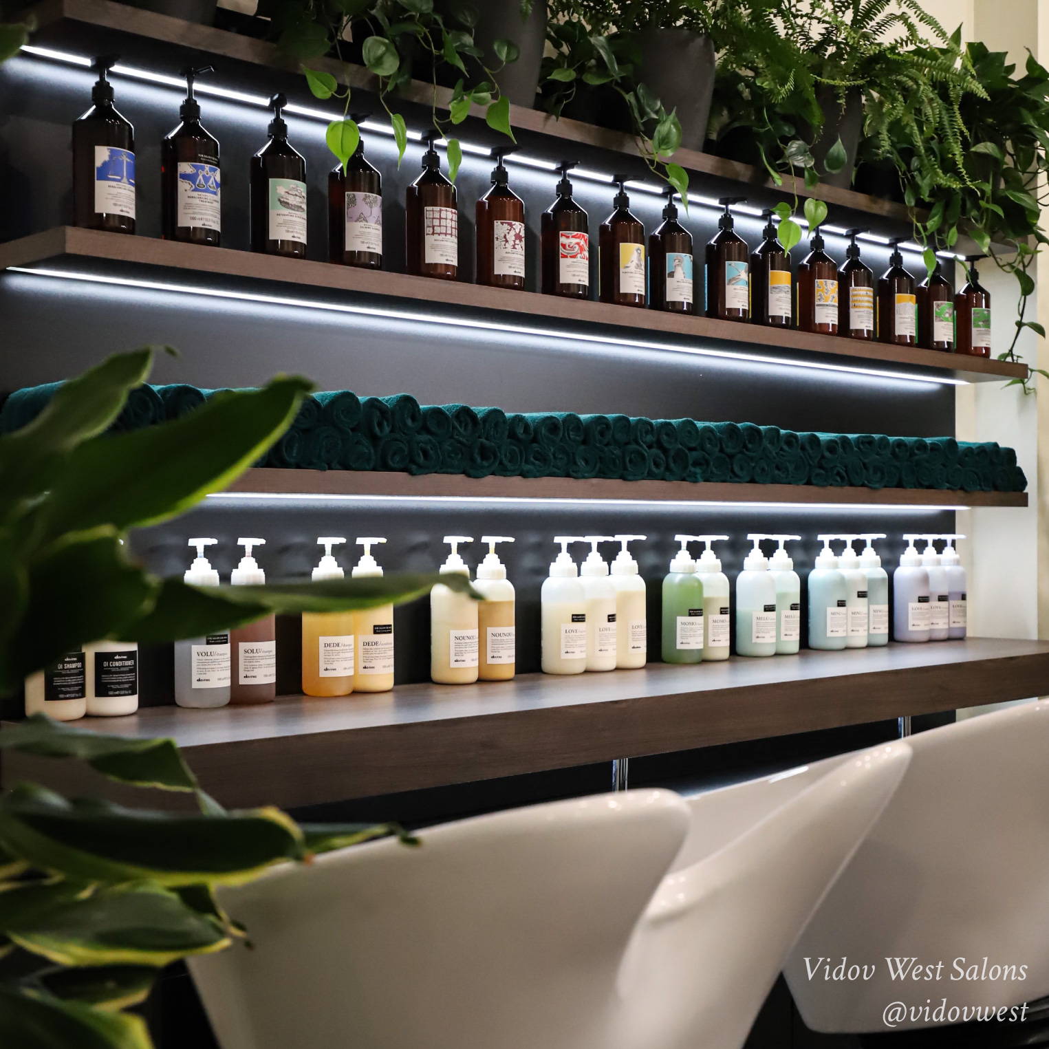 chic salon front desk with red shelves that have Davines Essential Haircare products