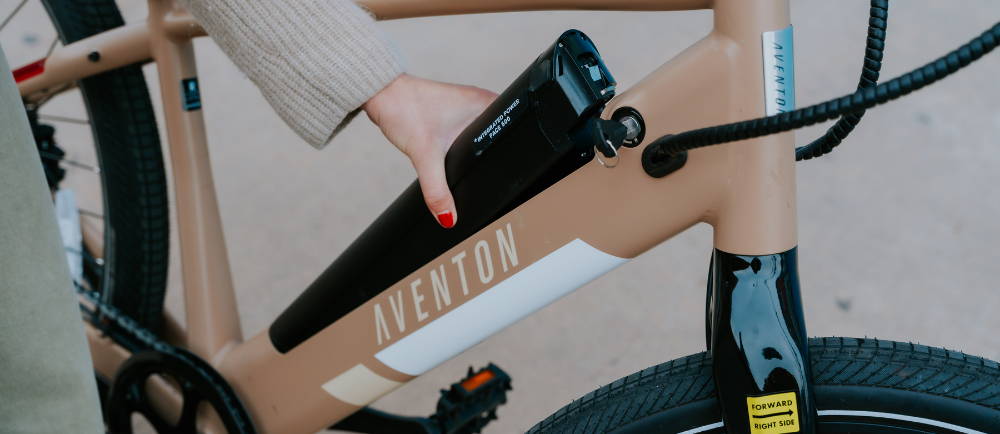 Rider removing battery from Aventon Pace 500 electric bike