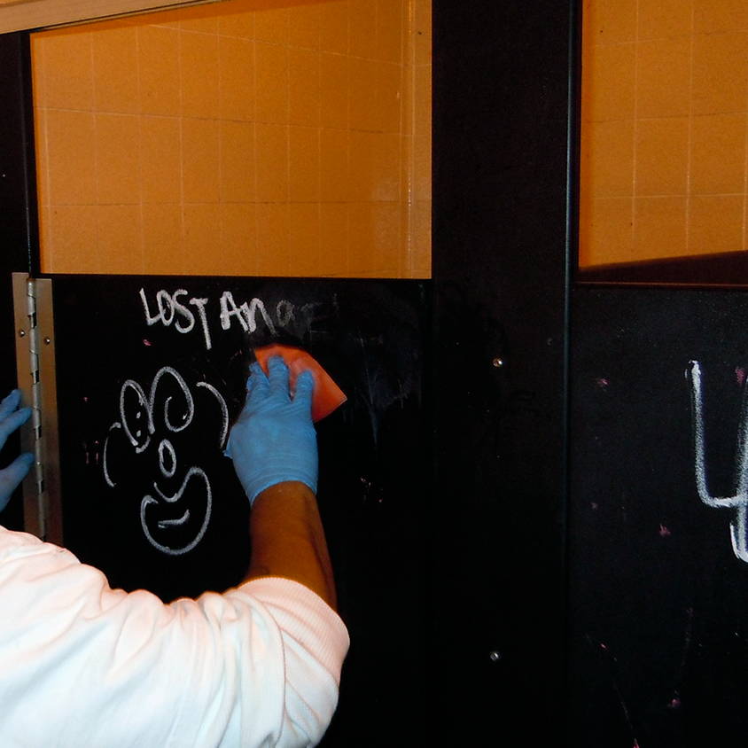 removing graffiti from bathroom stall