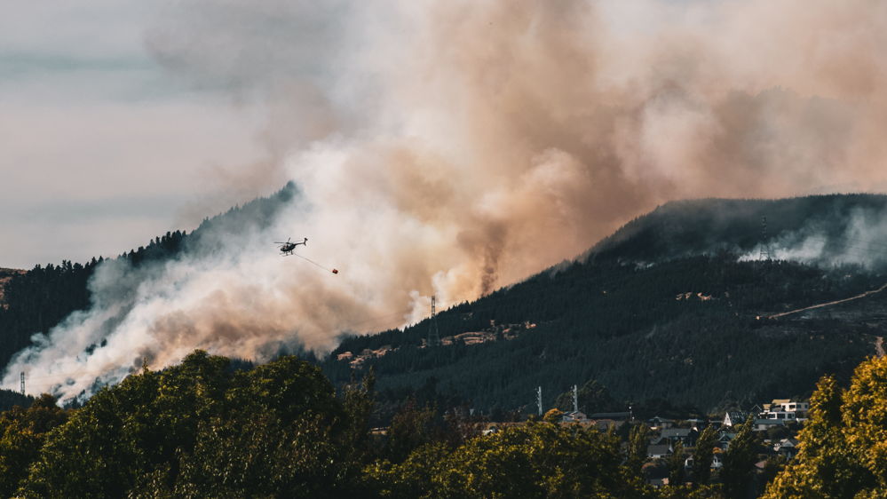 Helicopter flying in front of 2022 Port Hills fire