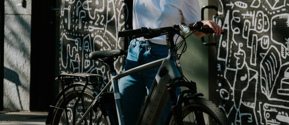 a woman standing next to a Gazelle Ultimate C380+ electric city bike