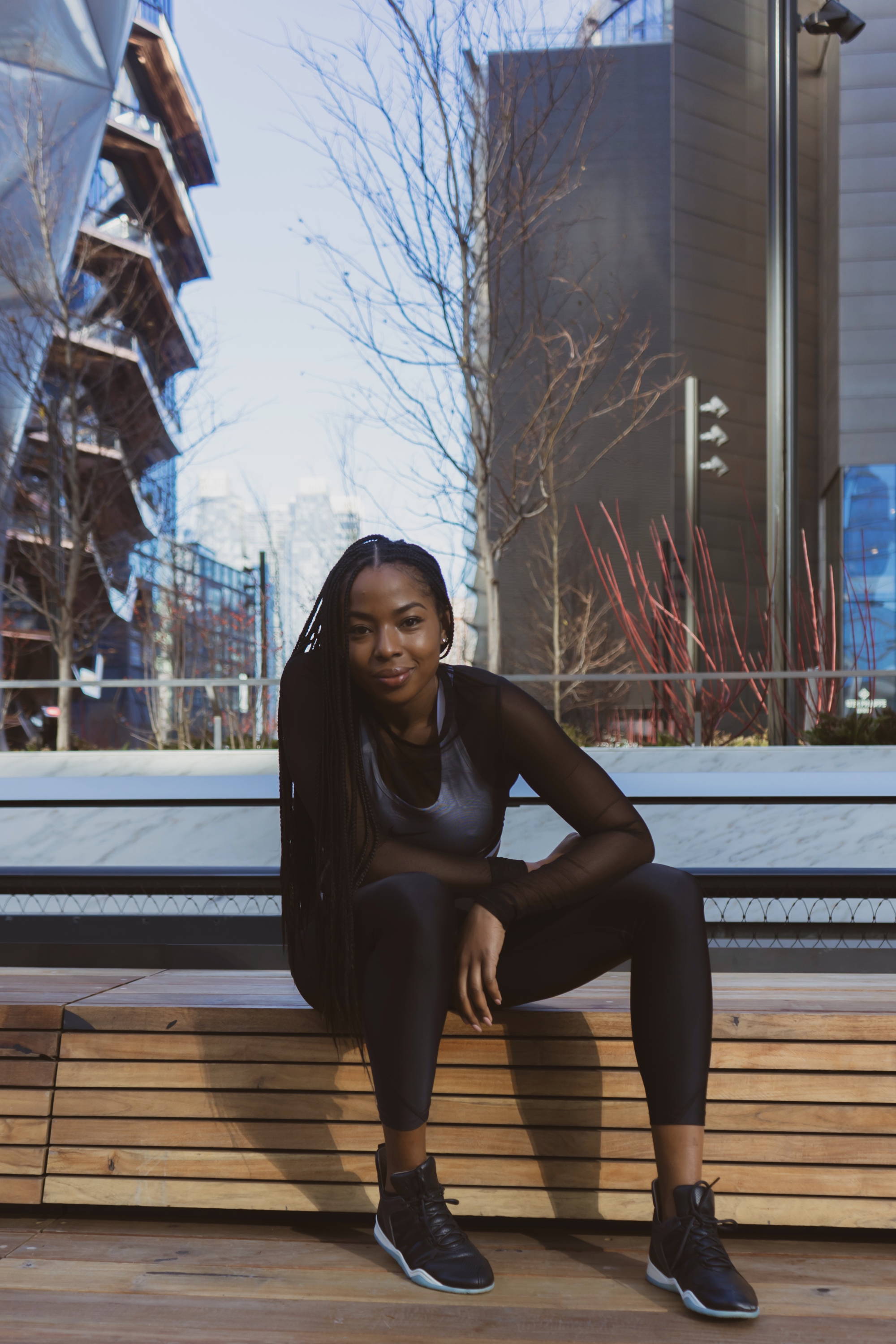 Kira West wearing Vobyo boxing sneakers in New York, posing on a bench