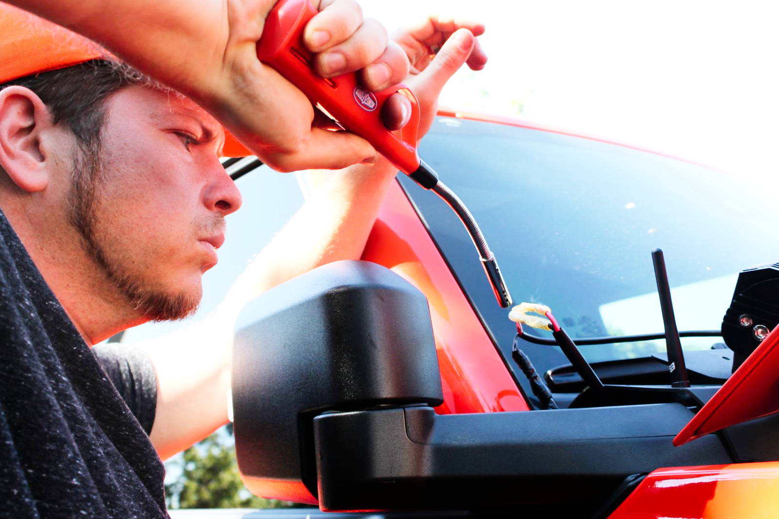 mike owner of m&r automotive uses heatgun to secure wiring on the hood mount light kit