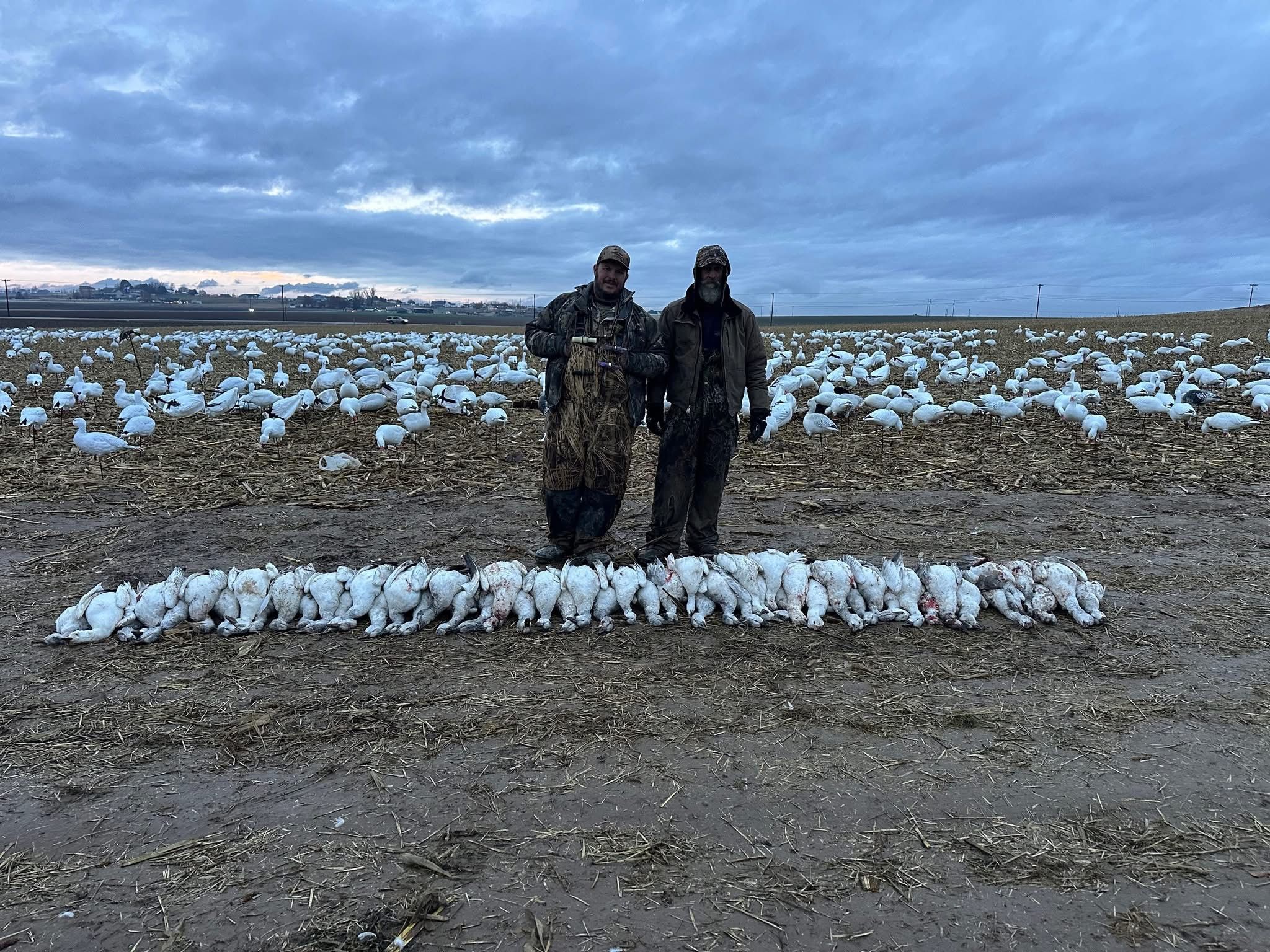 Two hunters silhouetted against the decoy spread
