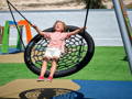 Kid enjoying a balance swing with their closed eyes