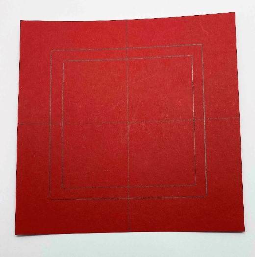 Guidelines are drawn on the large red card by drawing around the edges of the medium white card and small red card