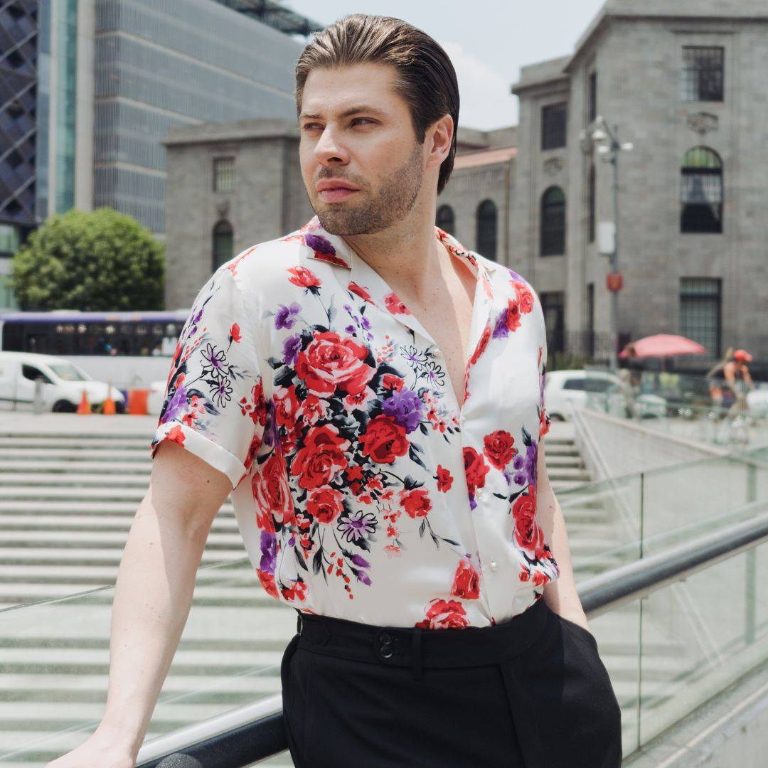 model walking outside wearing a short sleeve white floral silk shirt from 1000 kingdoms with high rise black pants