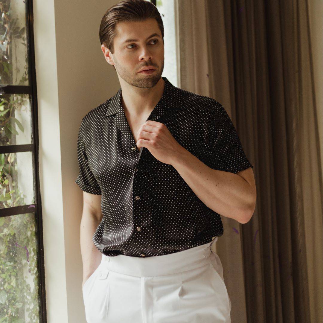 model wearing white pants and a short sleeve black dotted silk shirt from 1000 kingdoms
