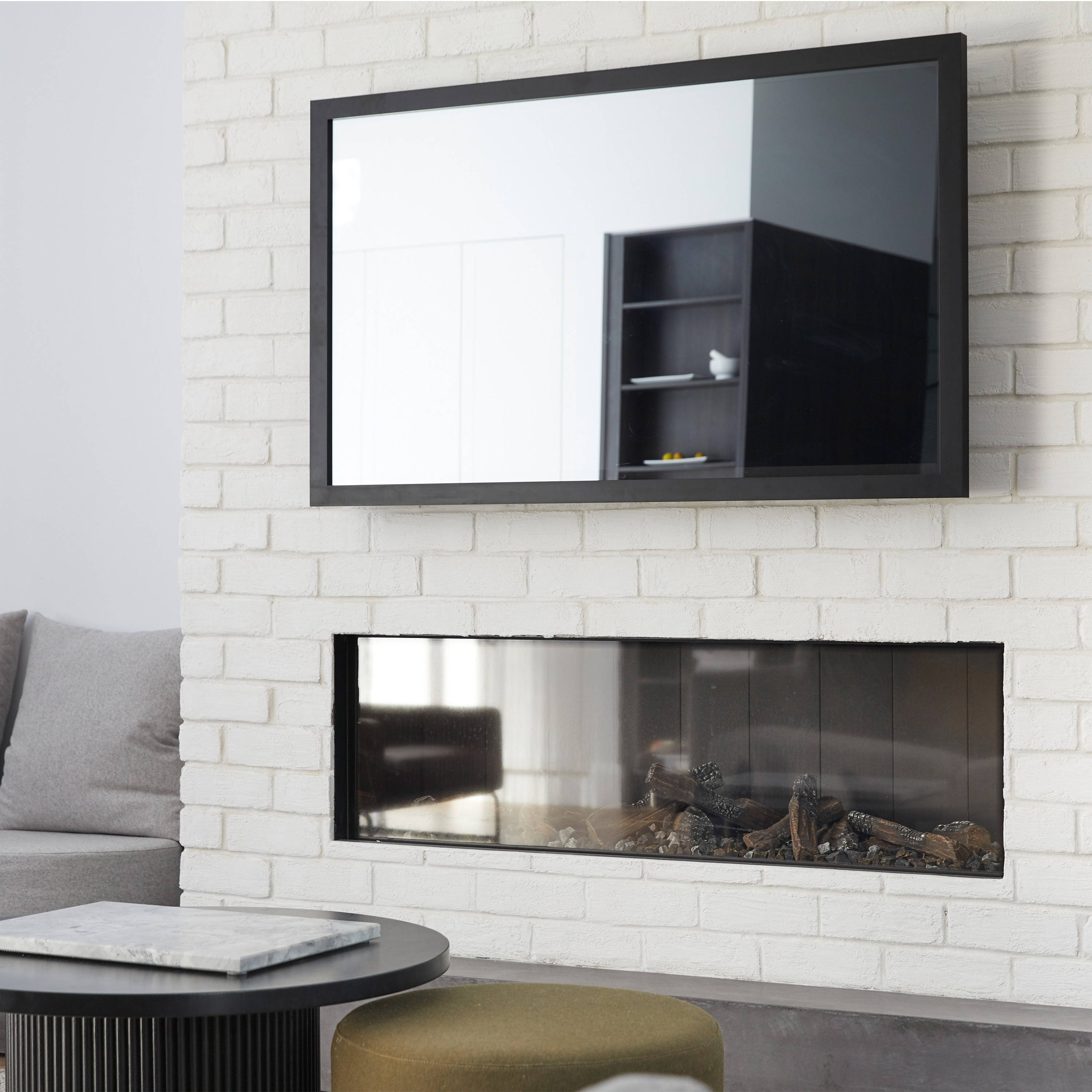 TV-Mirror with Matte Black Frame by FRAMING TO A T. A black framed mirror disguises the TV in this living room space as seen on The Block.