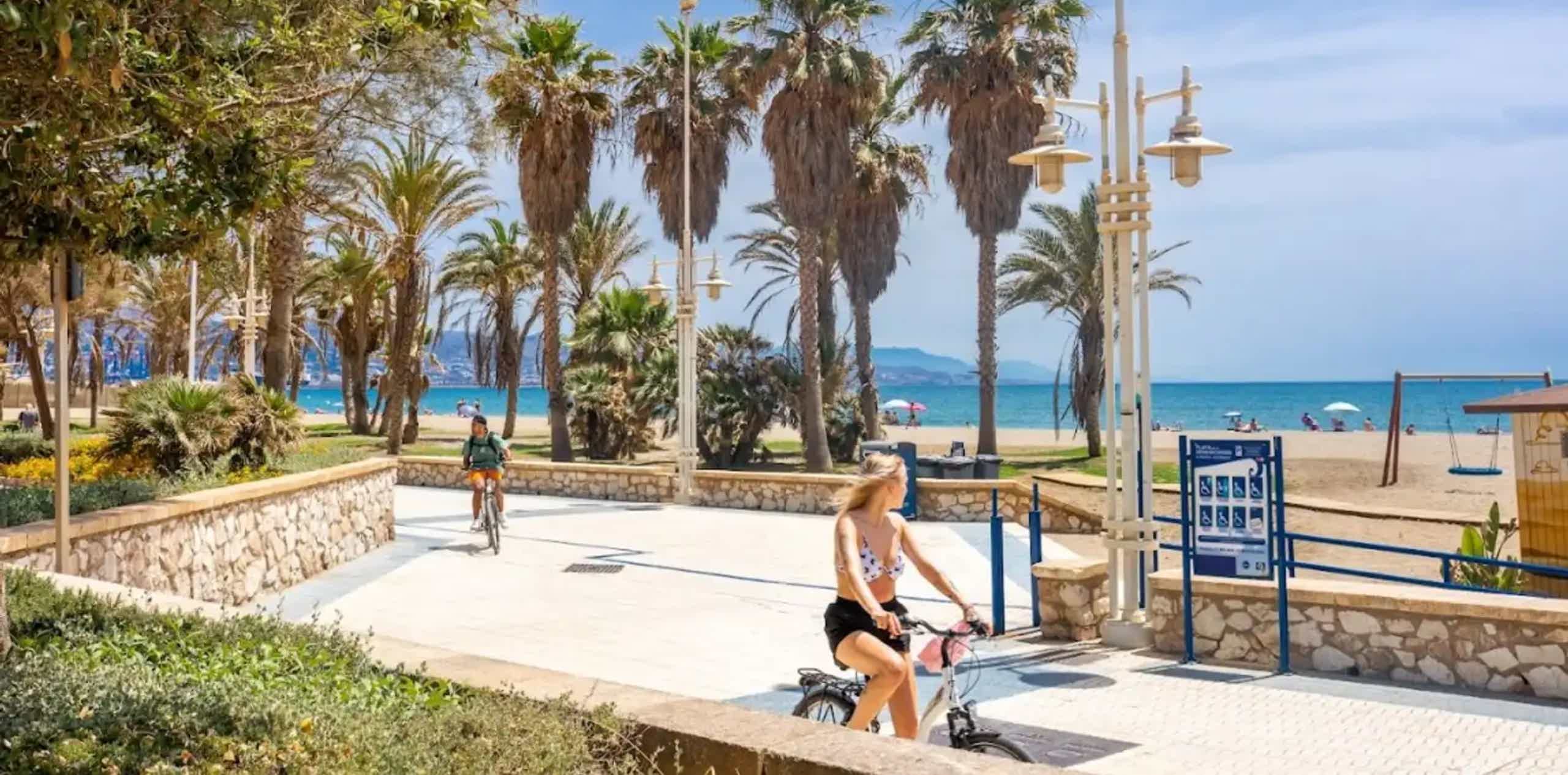 Imagen de recurso del paseo de Málaga frecuentado por dos personas sobre una e-bike.