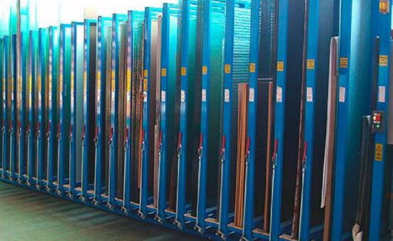 Plateaux de verre rangés verticalement dans le stock de l’atelier