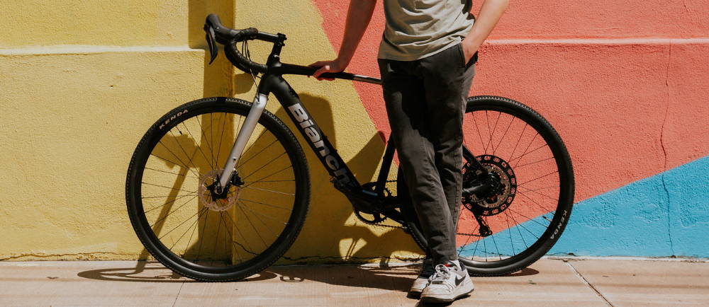 a man leaning against a Bianchi drop bar bike
