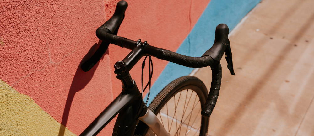 Handlebars of Bianchi E-Impulso electric road bike in front of colorful wall