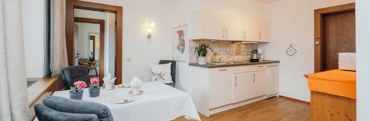helle und moderne Küche mit Essecke in gehobener Ferienwohnung in Oberstdorf.