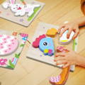 Children solving chicken-themed Easter wooden puzzle.