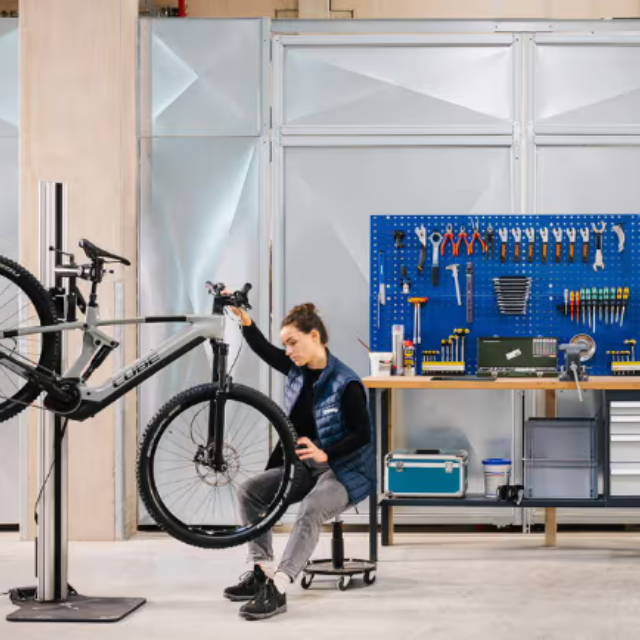 Mechanic inspecting ebike on repair stand