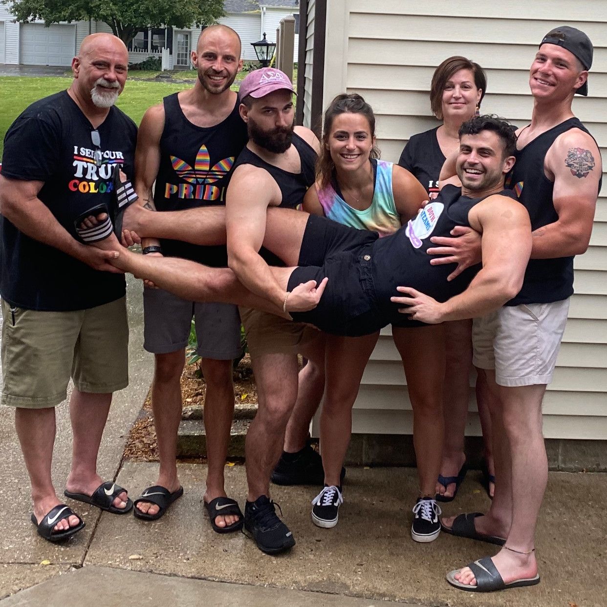 Blaize laying on top of his family who is carrying him, wearing custom t shirts