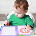 A little girl drawing on a Montessori Reusable Book using water pencil. 