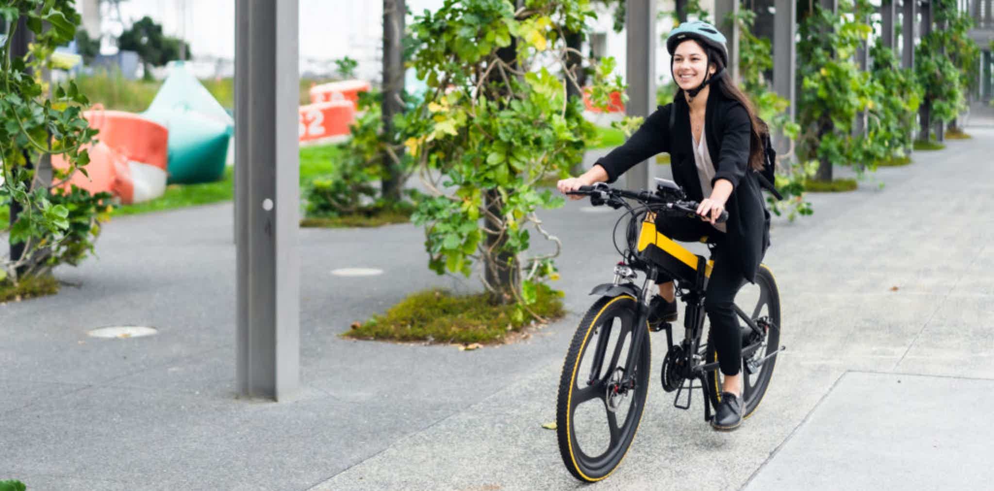 Imagen de recurso de una chica conduciendo una bicicleta eléctrica visiblemente feliz.