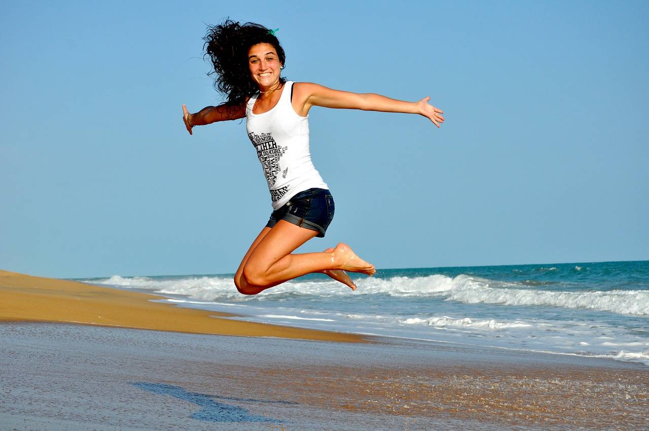 Girl jumping on the beach with energy