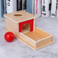 Montessori wooden toy with a permanence box and a red ball. 