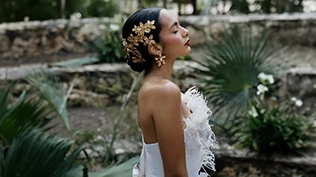 Un éditorial de mode mettant en scène des tenues haute couture blanches et dorées, photographié dans les jardins luxuriants de Tulum.