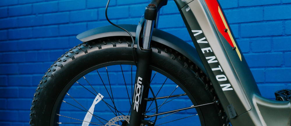 Aventon electric bike in front of blue wall