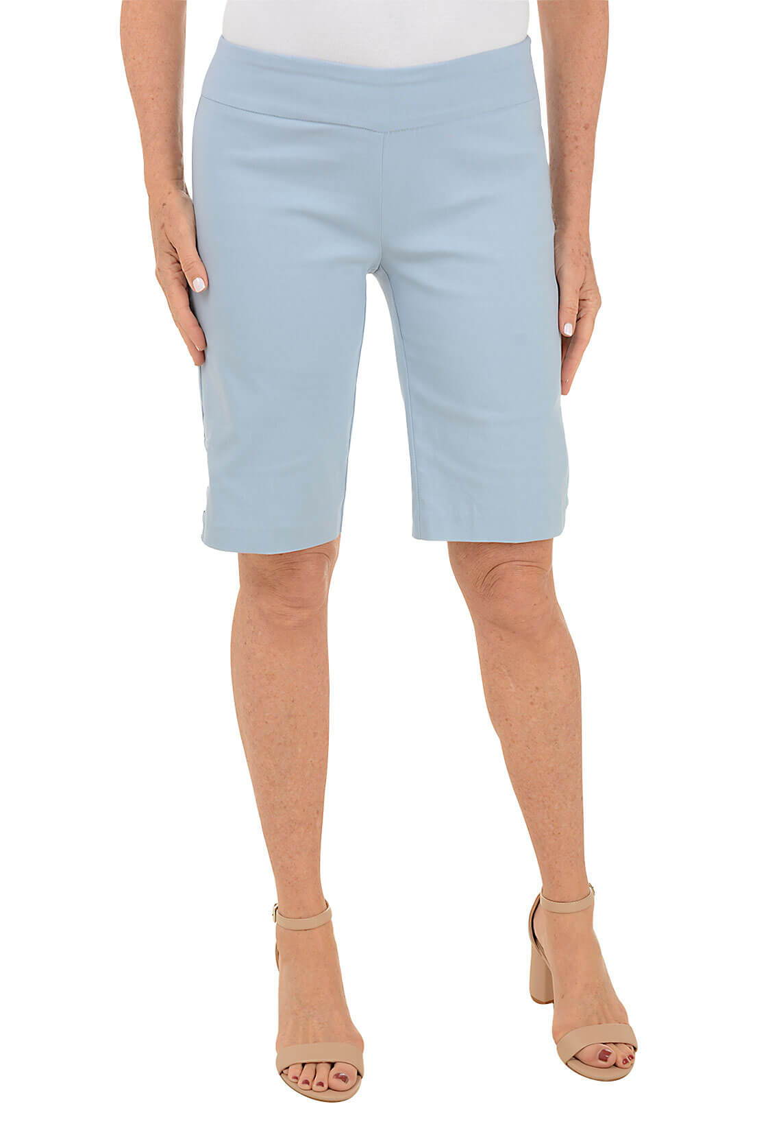 A woman wearing a light blue bermuda short against a white background