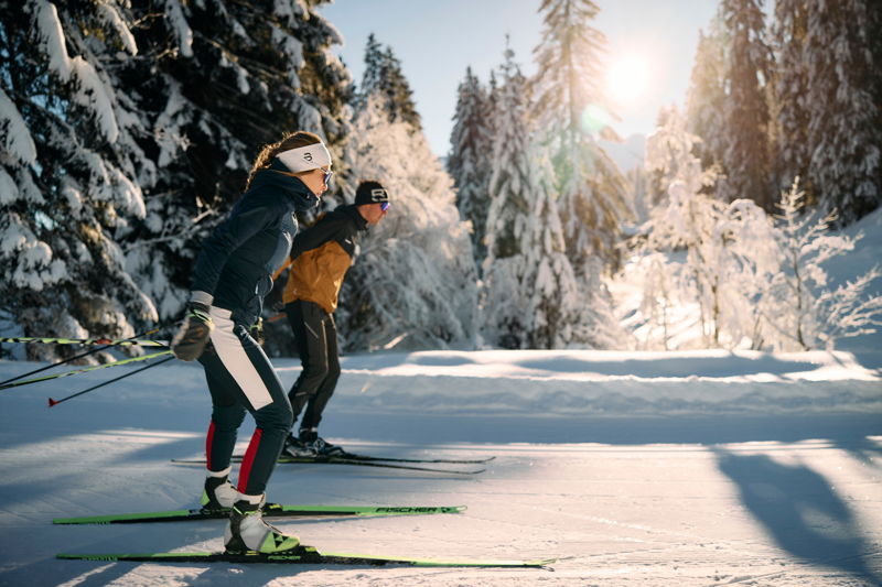 Langläufer auf einer Loipe im winterlichen Kleinwalsertal bei Sonnenschein.