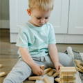 Little boy playing with wooden stacking blocks. 