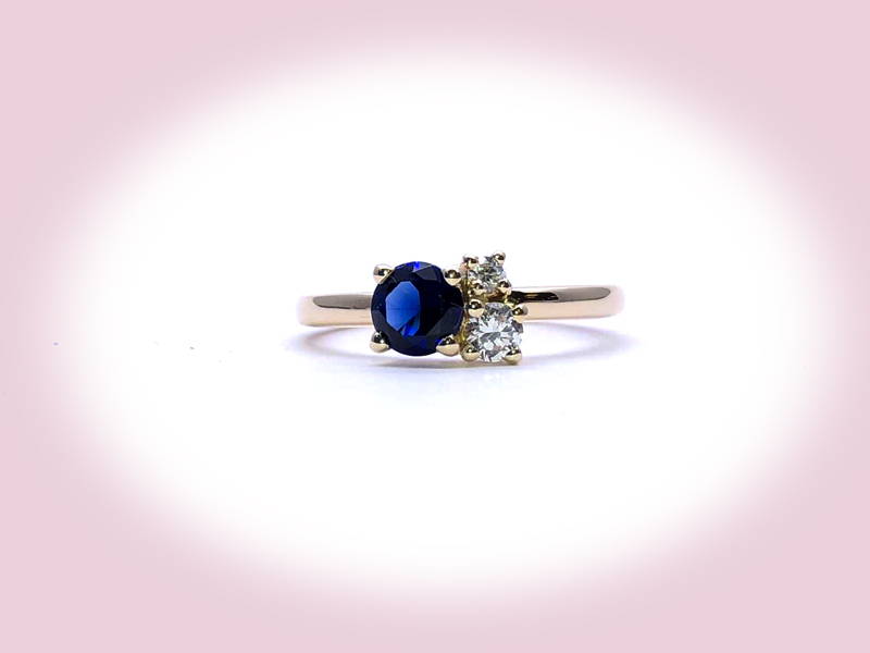 One sapphire and two diamonds on a fine yellow gold ring