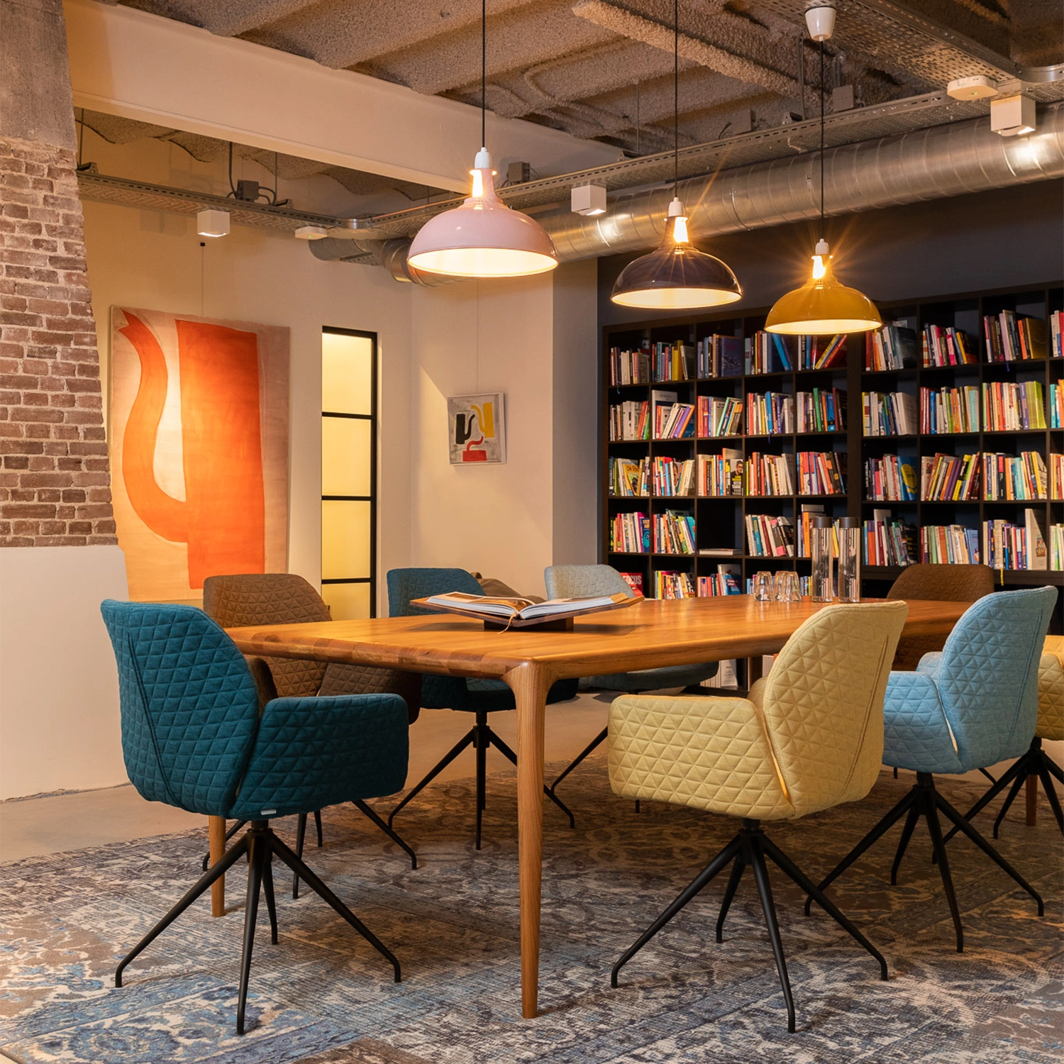 Three Large Coolicon lamps hang over a meeting table