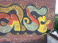 removing graffiti from multi-color spray painted brick wall