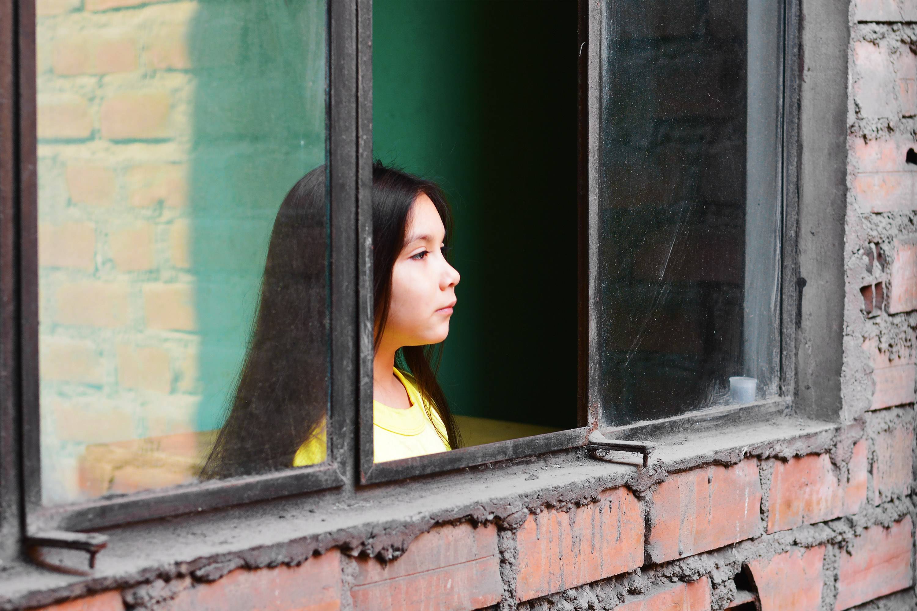 Young Brazilian girl gazing out of window