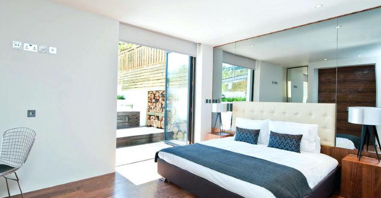 Chambre lumineuse avec portes de placard en miroir toute hauteur