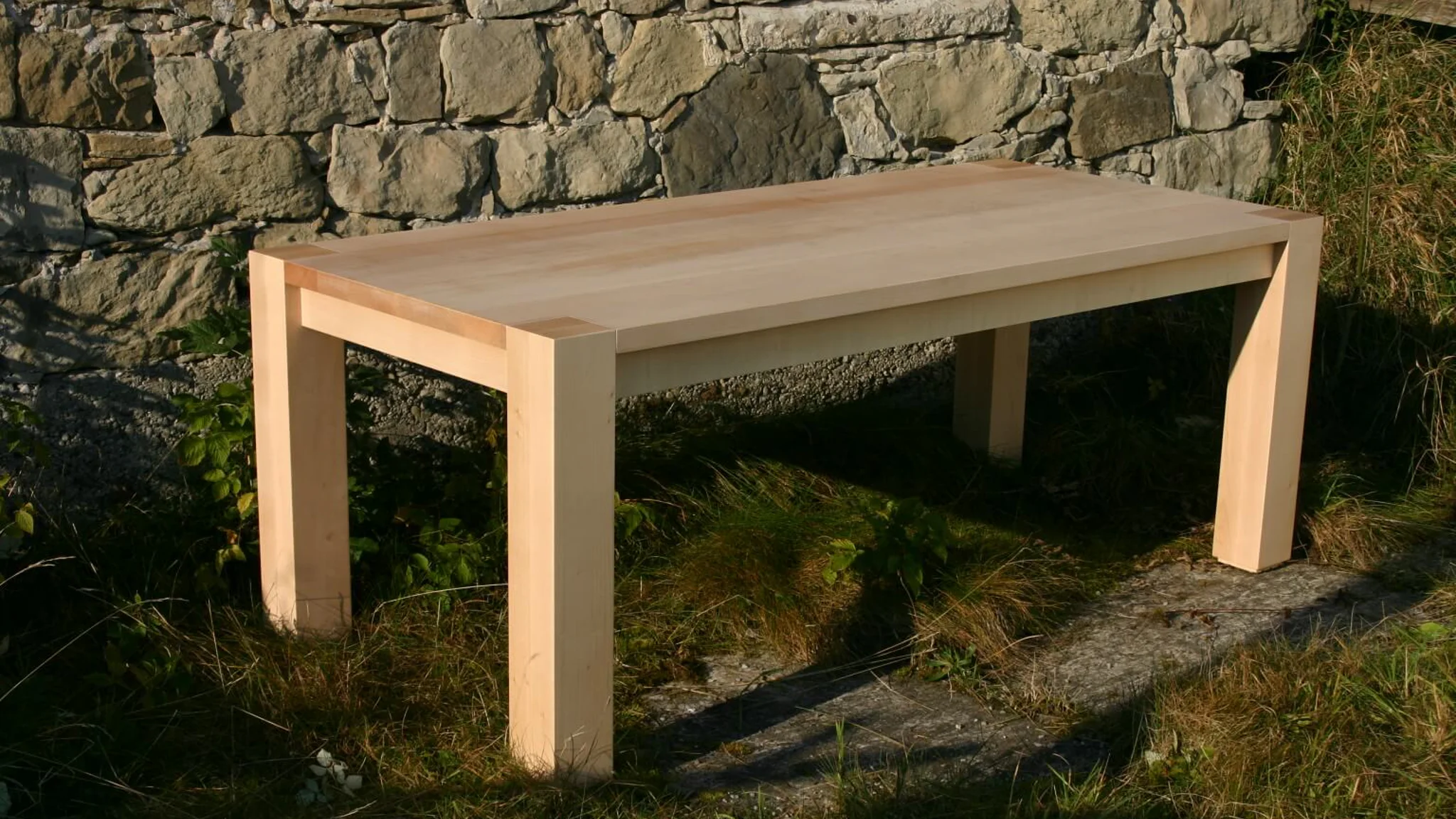 Tisch mit durchgehenden Eckbeinen