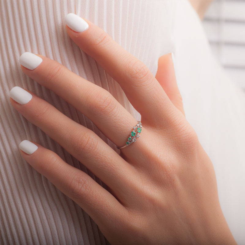 emerald cluster ring on a hand