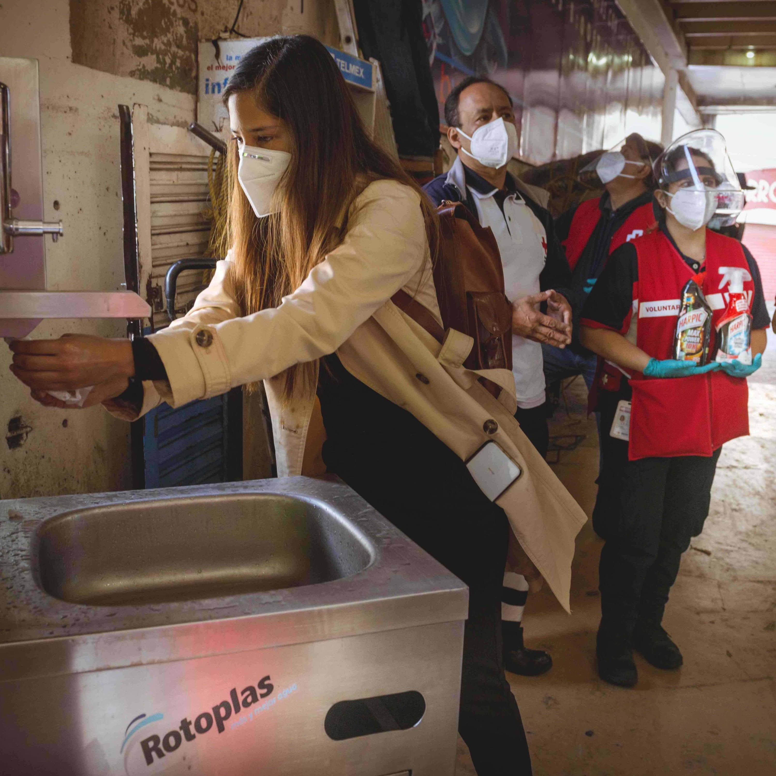 Mujer usando nuestra estación de agua en la Central de Abasto