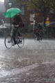 Homme à vélo sous une pluie battante. 