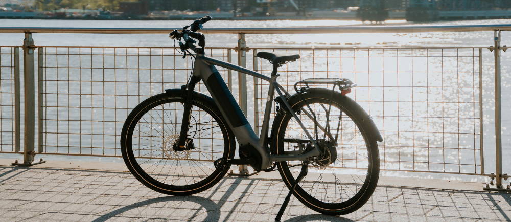 a Gazelle Ultimate C380+ electric city bike in a city by a river