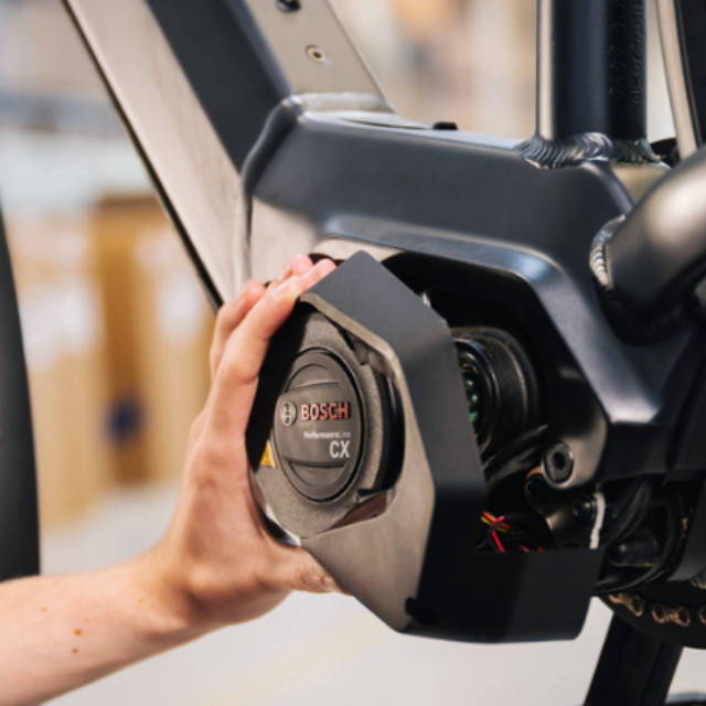 a person installing a bosch motor on a mid drive electric bike