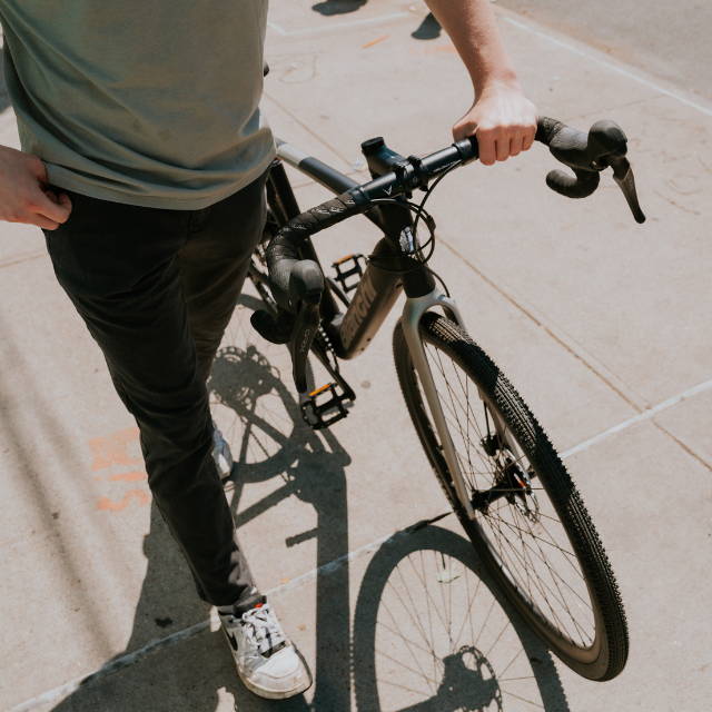 a man standing next to a Bianchi E-Impulso electric road bike